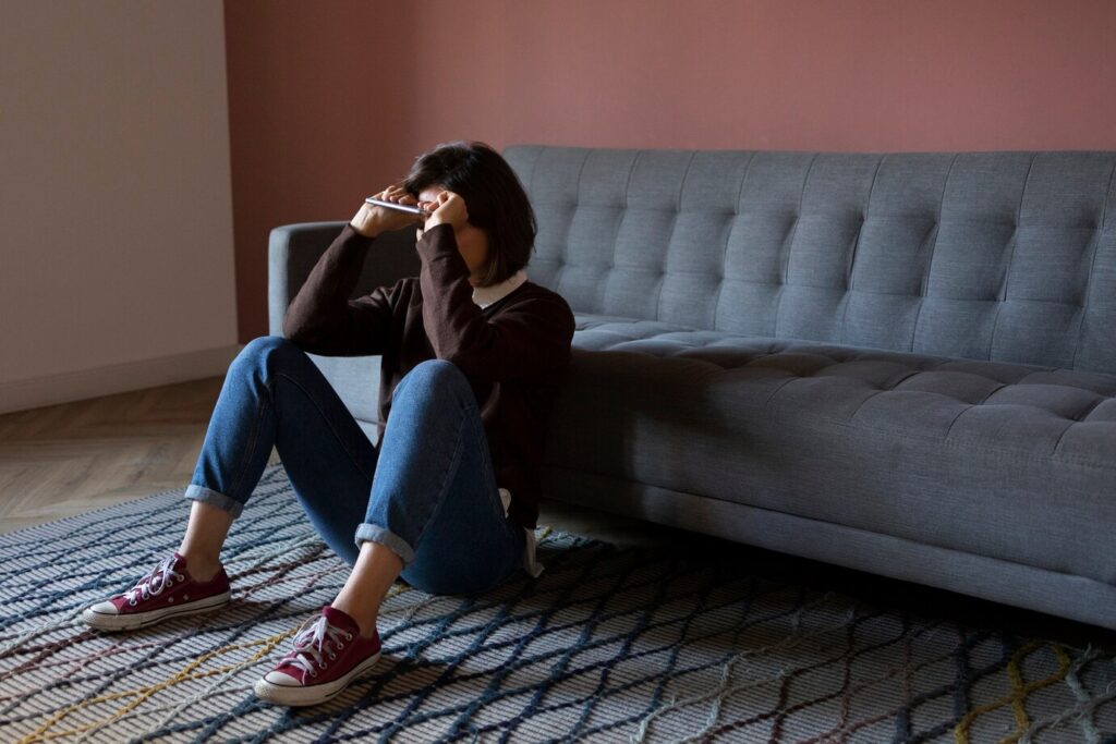 woman sitting on couch experiencing bipolar disorder